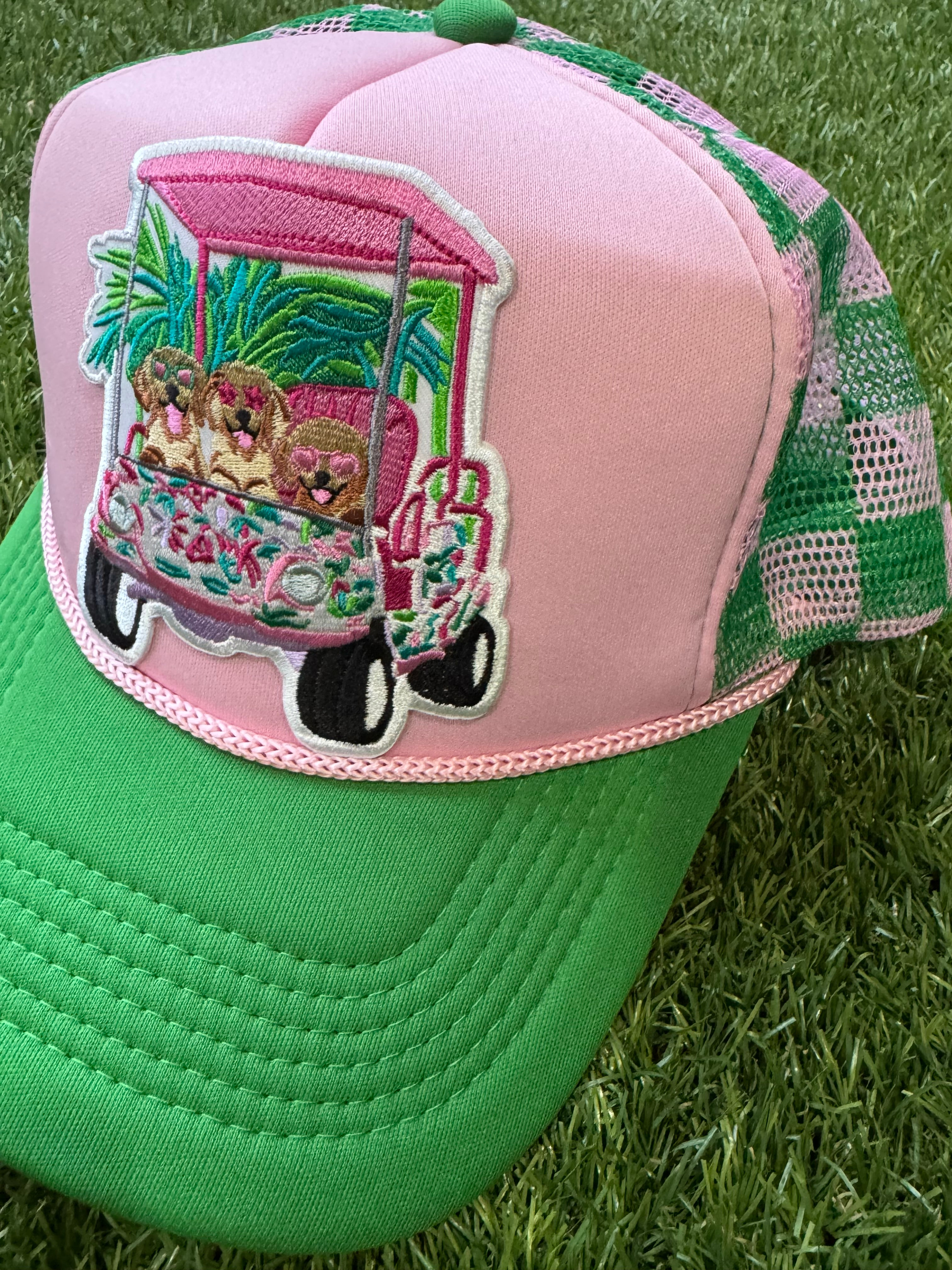 Dogs on a golf cart on pink/green mesh trucker hat